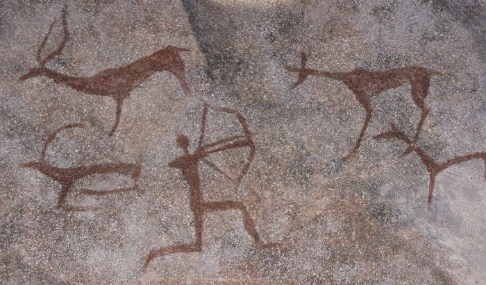 Figure animals and hunter on the stone wall of the cave paint ocher ancient prehistoric Neanderthal. prehistoric animal, stone age hunting for deer